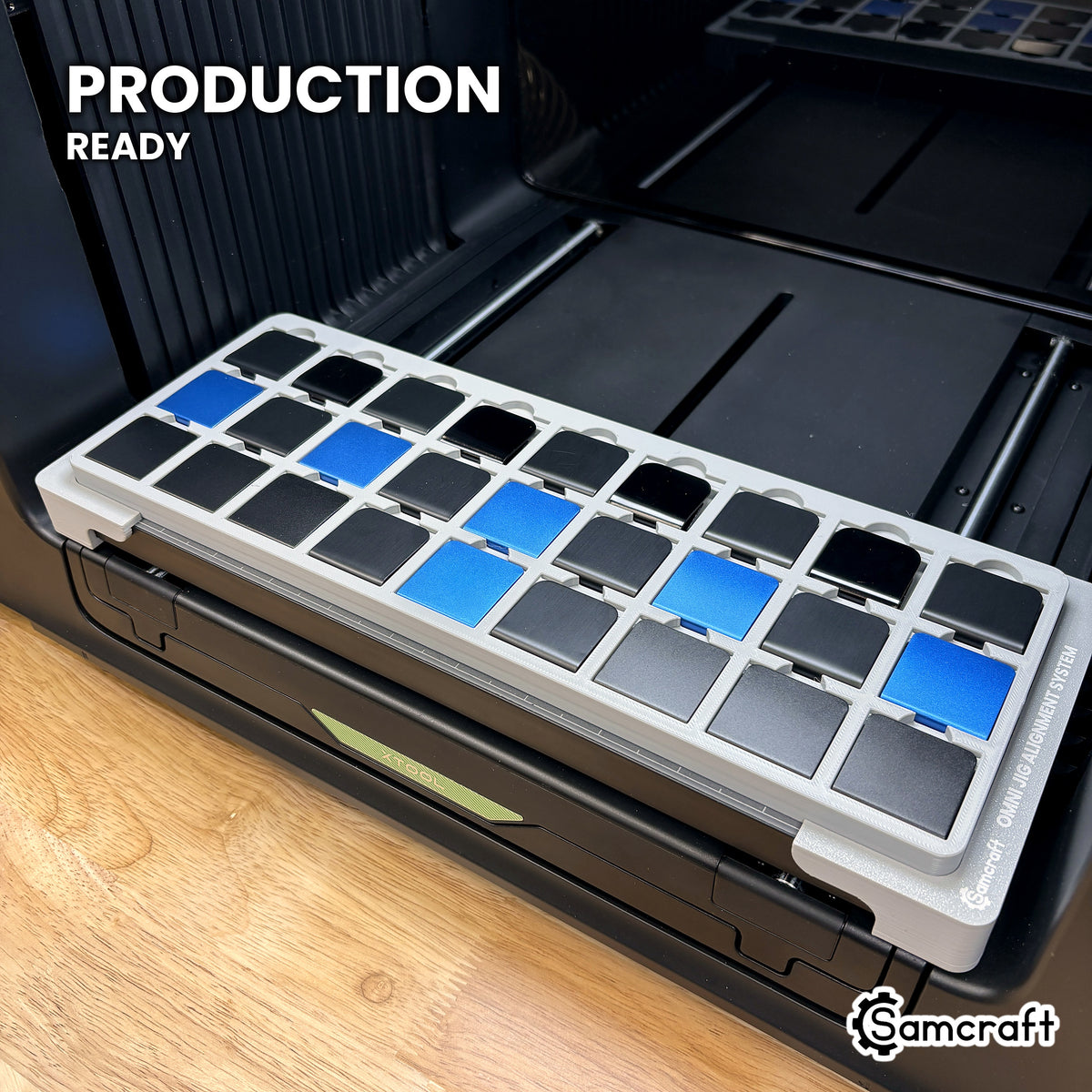 Samcraft hat clip jig loaded with twenty-seven clips on the xTool Omni UV printer bed, set up for production runs.