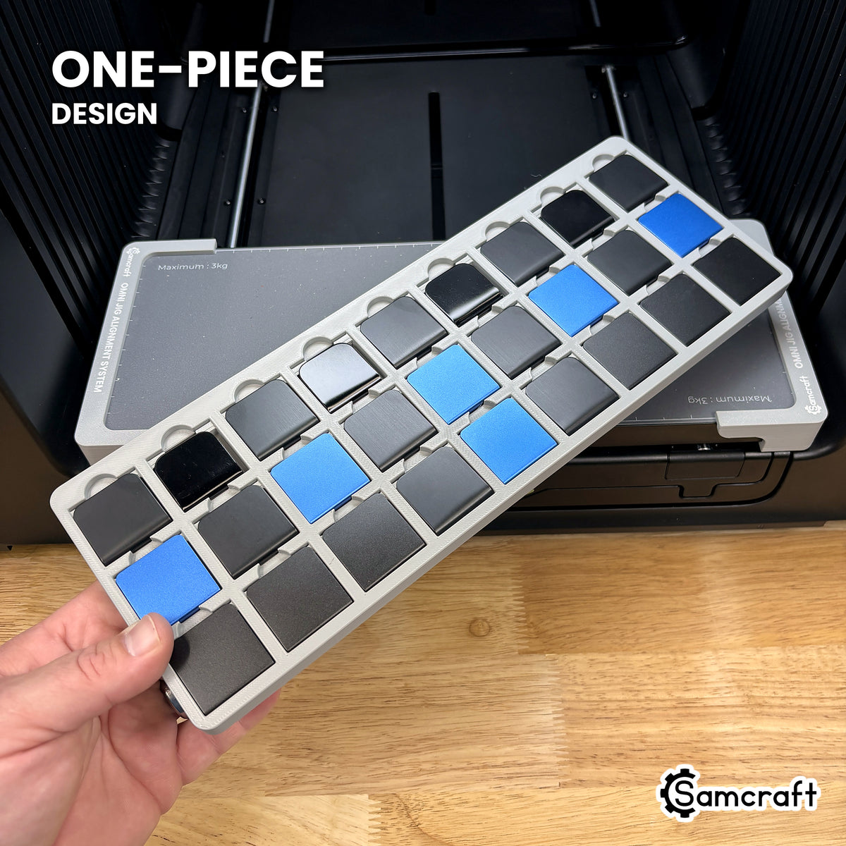 Hand holding the one-piece Samcraft hat brim clip jig for the xTool Omni, twenty-seven clips seated in a single molded tray.