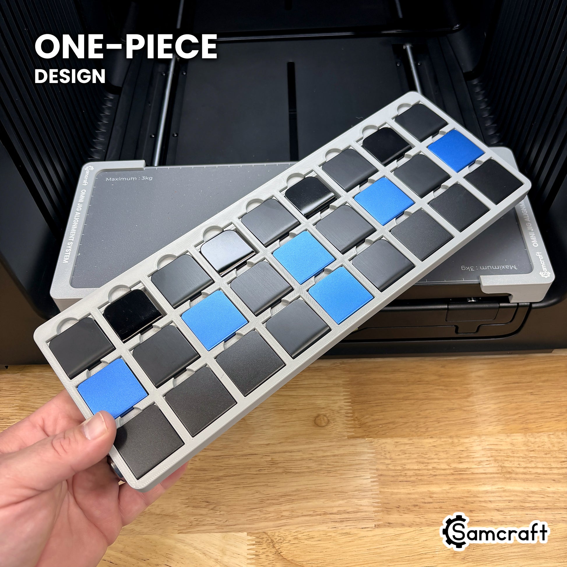 Hand holding the one-piece Samcraft hat brim clip jig for the xTool Omni, twenty-seven clips seated in a single molded tray.