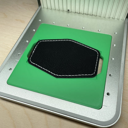 Samcraft hex patch jig in an xTool F1 laser bed, holding a black hexagonal leatherette patch.