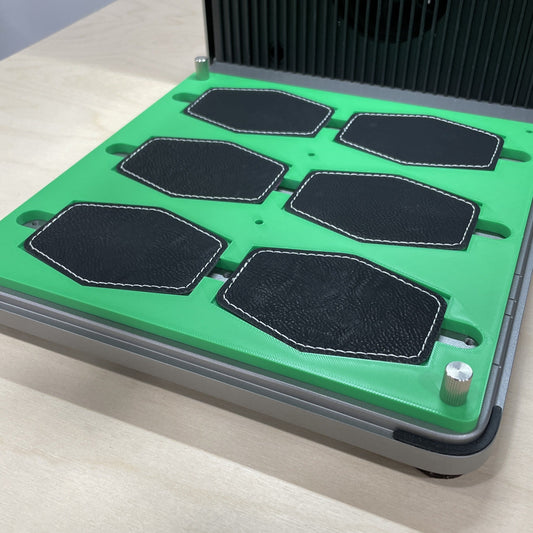 Samcraft green hex patch jig in an xTool F1 Ultra laser bed, holding six black hexagonal leatherette patches.