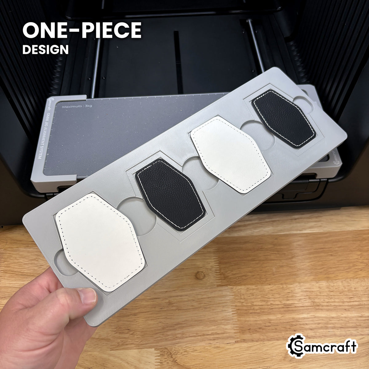 Hand holding the one-piece Samcraft hex patch jig for the xTool Omni, four patch pockets in a single molded tray.