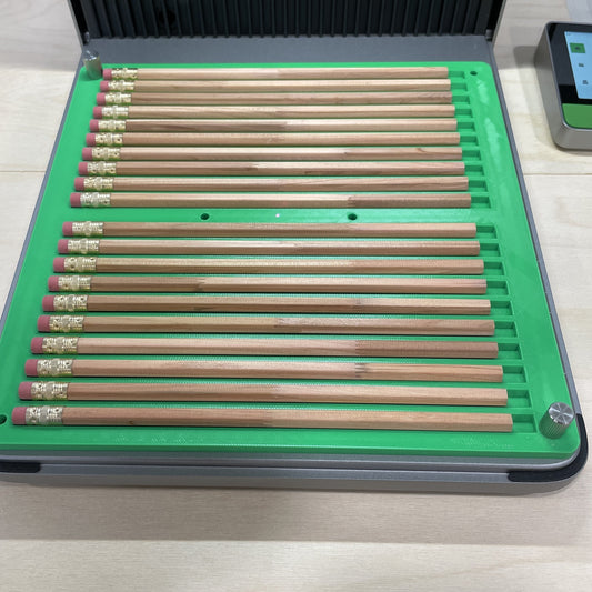 Samcraft green hexagon pencil jig in an xTool F1 Ultra laser bed, holding a full row of wooden pencils.
