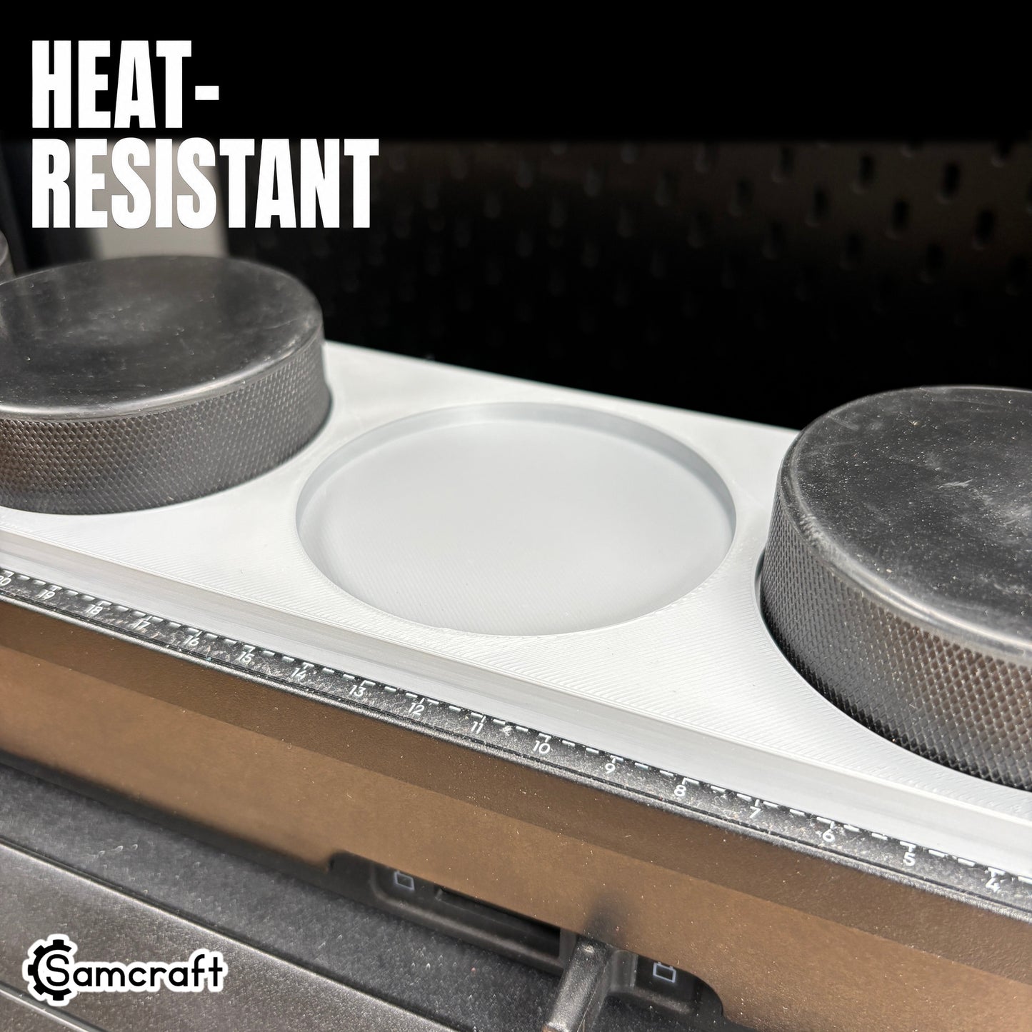 Hockey Puck Jig for the eufyMake E1 — close-up of the gray 3D-printed tray showing an empty round puck pocket between two black hockey pucks, with the built-in ruler, highlighting the heat-resistant material.