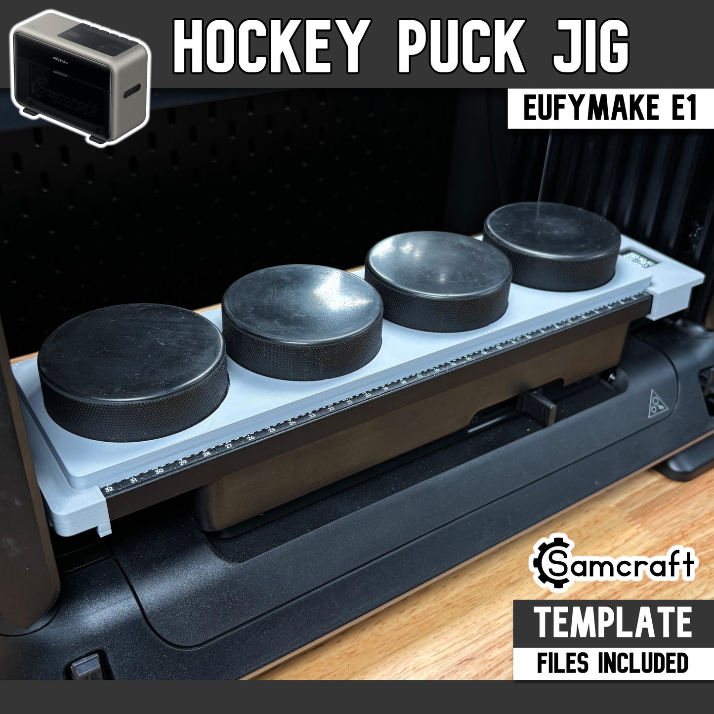 Hockey Puck Jig for the eufyMake E1 UV printer — gray one-piece 3D-printed tray holding four black hockey pucks in a row, each seated in a round recessed pocket, with a built-in alignment ruler along the front edge; template files included.