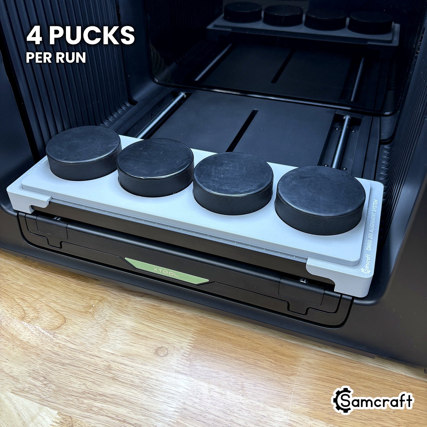 Samcraft hockey puck jig for the xTool Omni loaded with four regulation hockey pucks, a full four-puck run in a single pass.
