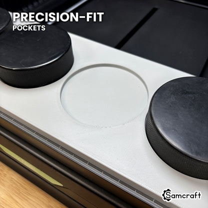 Close-up of an empty true-circle pocket in the Samcraft hockey puck jig for the xTool Omni, with pucks seated in the pockets either side.
