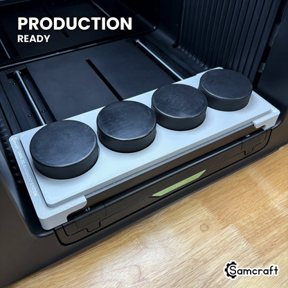 Samcraft hockey puck jig holding four regulation pucks on the xTool Omni UV printer bed, set up for production runs.