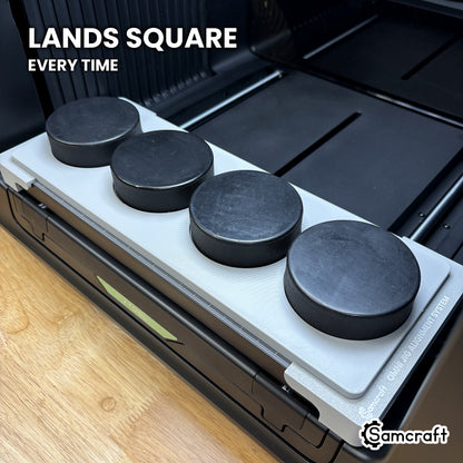 Samcraft hockey puck jig dropped into the Omni Jig Alignment System with four pucks loaded, landing square and centered on the printer bed.