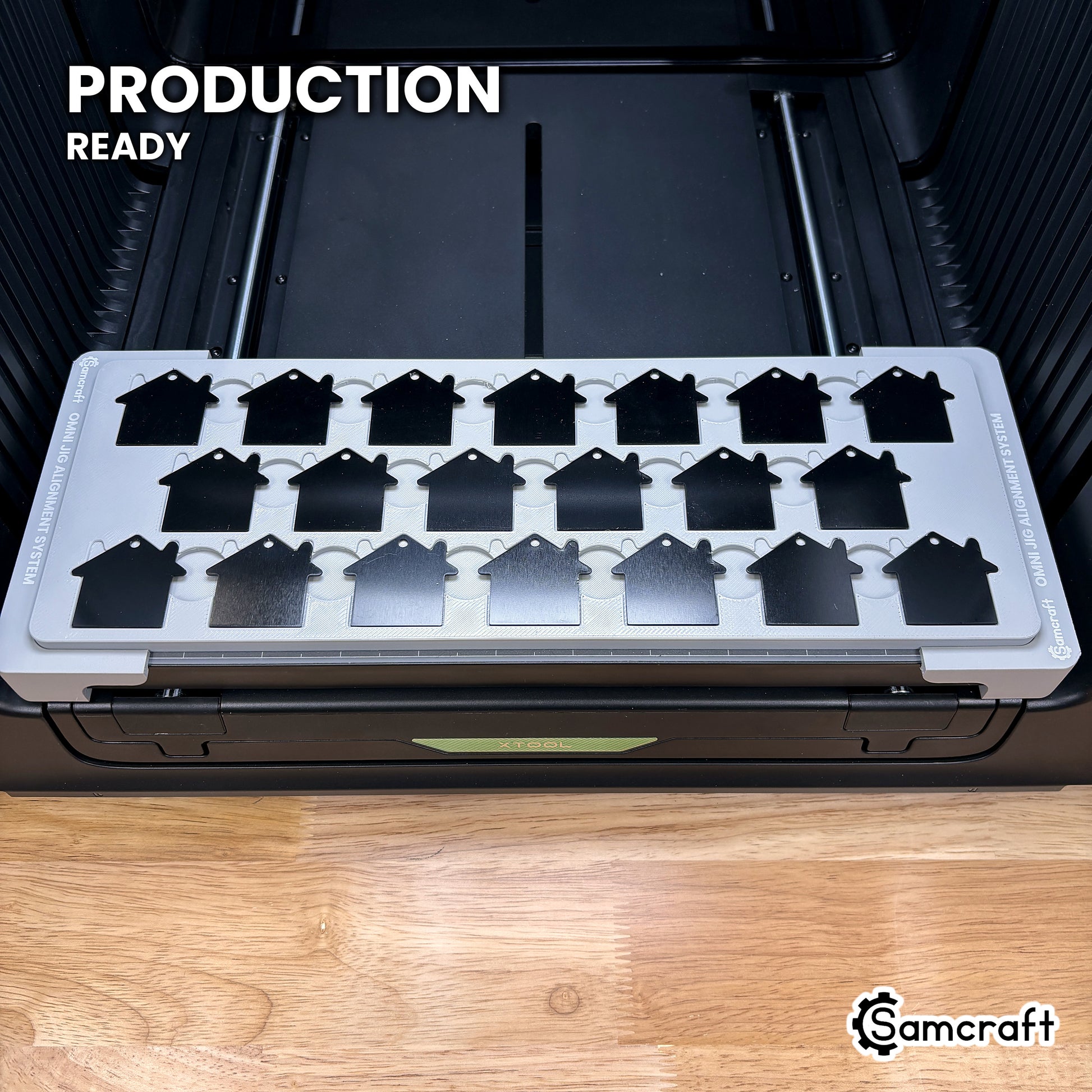 Samcraft house tag jig loaded with twenty-one tags on the xTool Omni UV printer bed, set up for production runs.