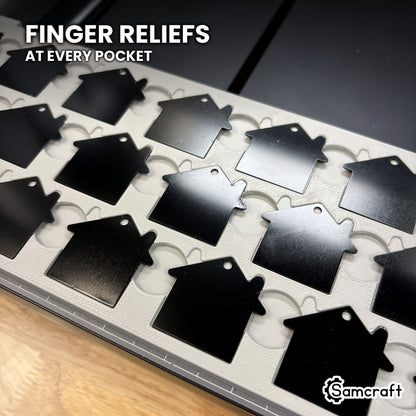 Close-up of the finger reliefs at every pocket of the Samcraft xTool Omni house tag jig, for lifting a printed tag out cleanly.