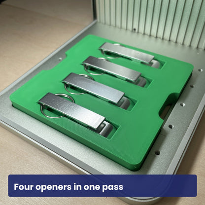 Keychain bottle opener jig loaded with four metal openers, showing all four slots in use.