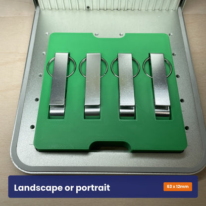 Keychain bottle opener jig holding openers turned upright, showing it works in portrait as well as landscape.
