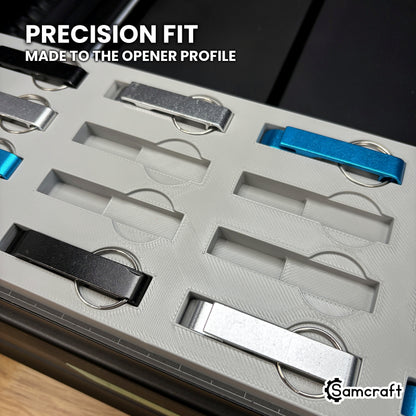 Close-up of the empty pockets in the Samcraft keychain bottle opener jig, each with a curved recess for the split ring, beside loaded openers.