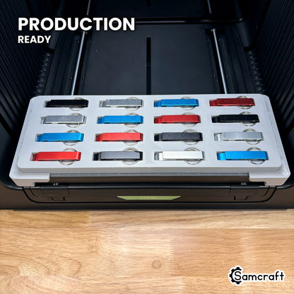 Samcraft keychain bottle opener jig loaded with sixteen openers on the xTool Omni printer bed, set up for production runs.