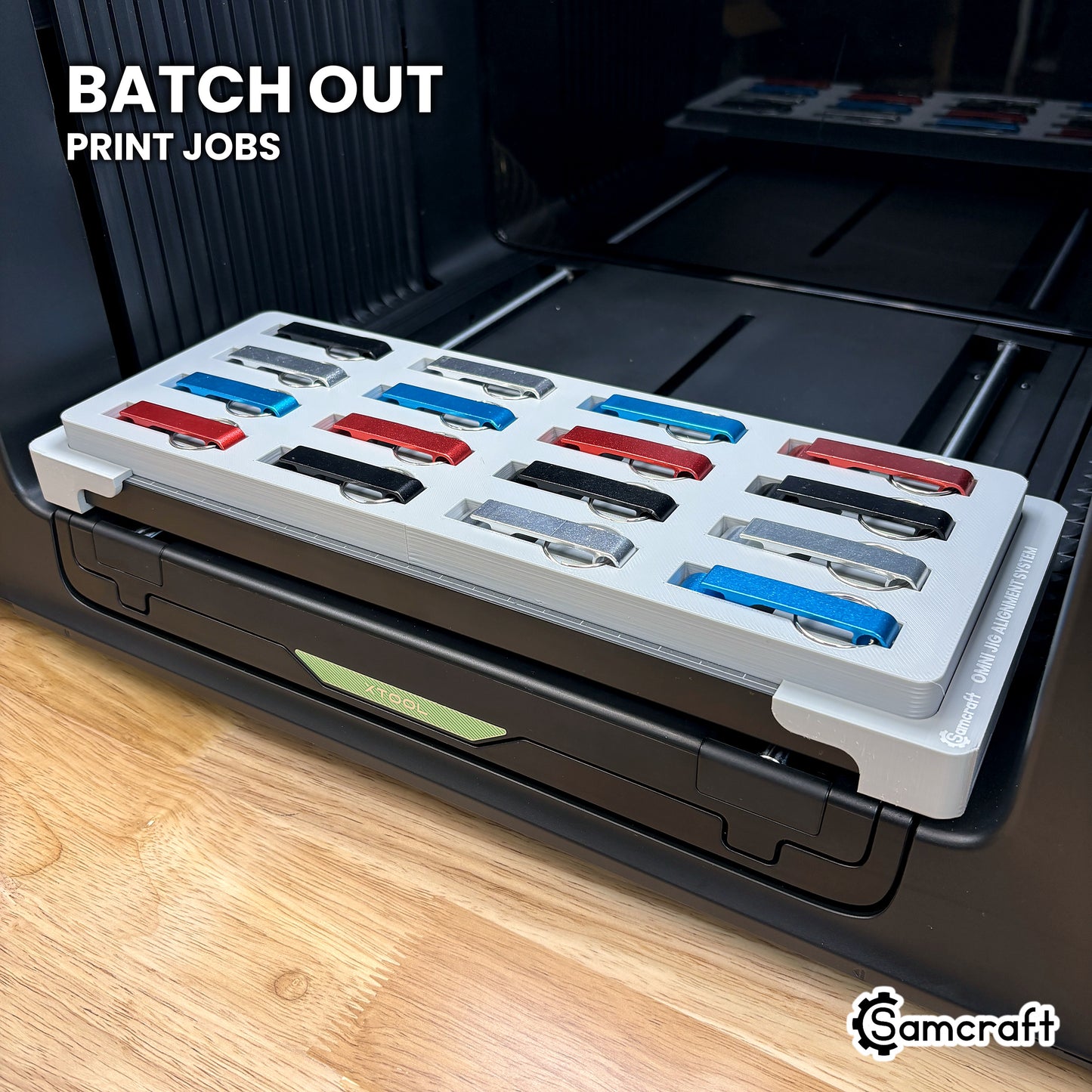 Samcraft keychain bottle opener jig filled with sixteen mixed-color openers on the xTool Omni UV printer, ready to batch out print jobs.