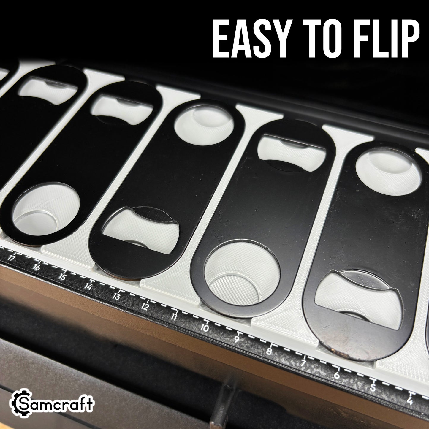 Oval Metal Bottle Opener Keychain Jig for the eufyMake E1 — close-up of the gray 3D-printed tray pockets with black oval bottle openers, some flipped to show both orientations, highlighting how easy they are to flip.