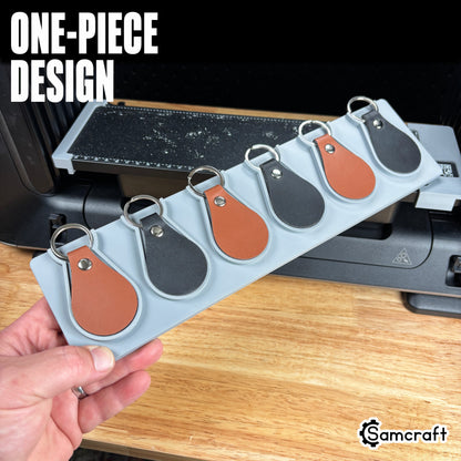 leather-key-fob-jig-eufymake-one-piece-design.jpg

Leather Key Fob Jig for the eufyMake E1 — hand holding the gray one-piece 3D-printed tray loaded with six leather key fobs in cognac and black, each in its own molded pocket, showing the solid single-piece design.