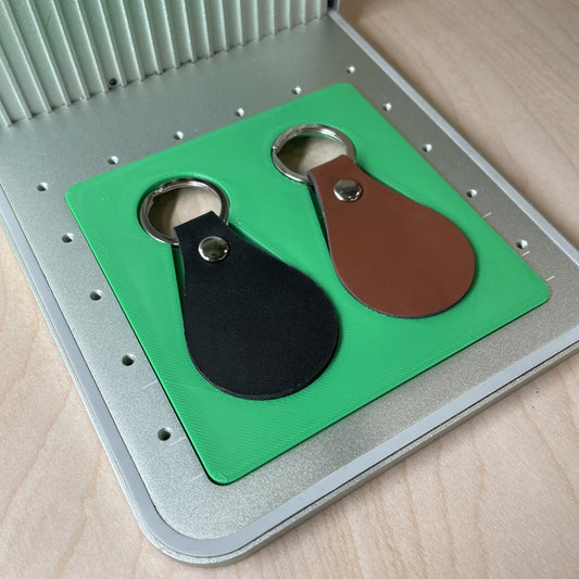 Samcraft leather key fob jig in an xTool F1 laser bed, holding a tan leather key fob.