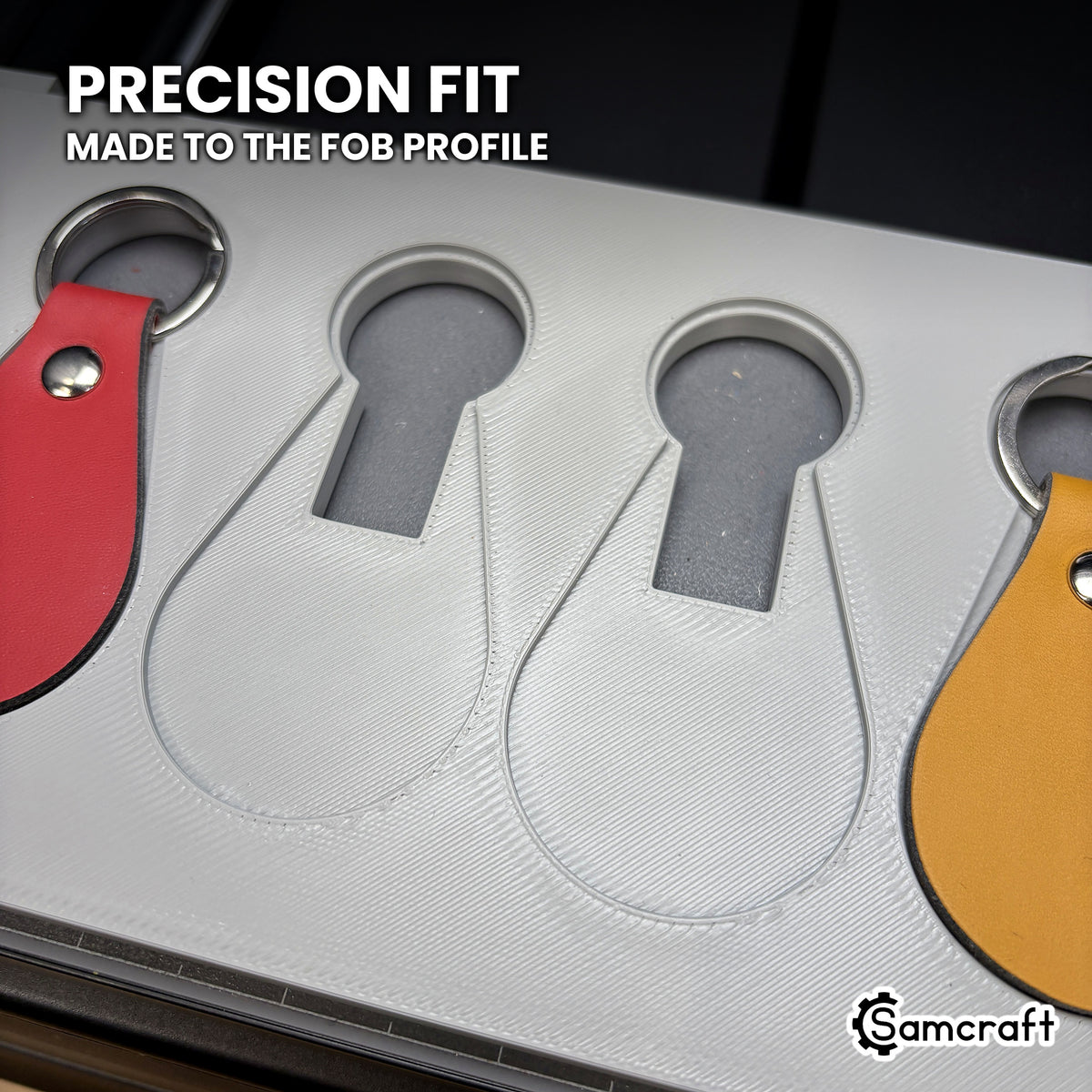 Close-up of the empty teardrop pockets in the Samcraft leather key fob jig, each with a round recess at the top for the split ring.