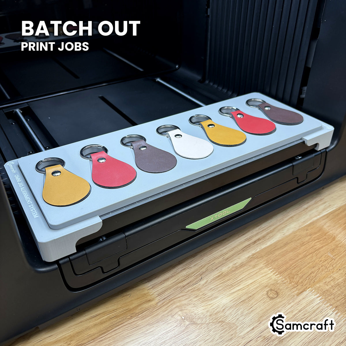 Samcraft leather key fob jig filled with seven leather fobs on the xTool Omni UV printer, ready to batch out print jobs.