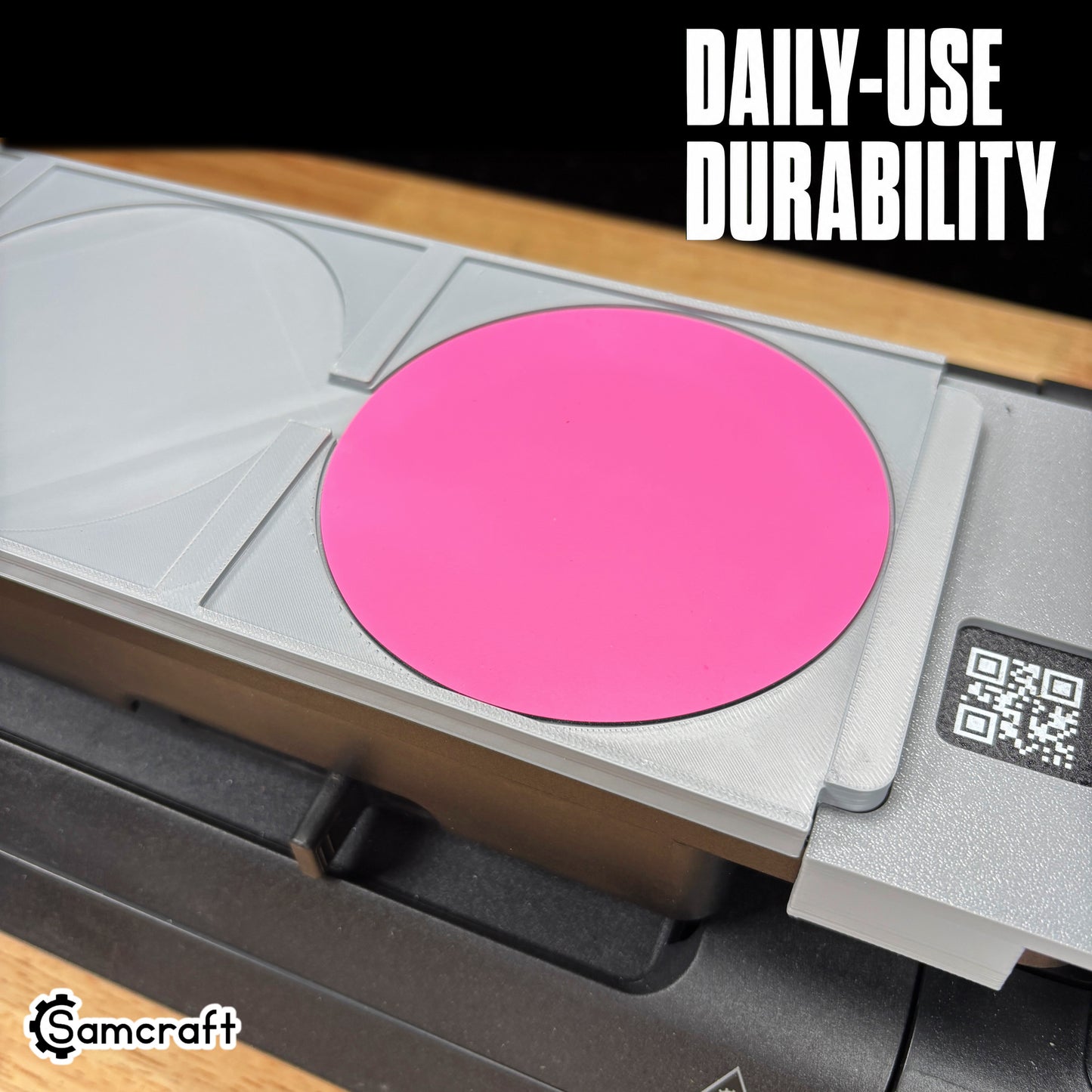 Close-up of the Samcraft Leather/Silicone Drink Coaster Jig holding a pink round coaster in a durable gray tray with recessed pockets on the eufyMake E1.
