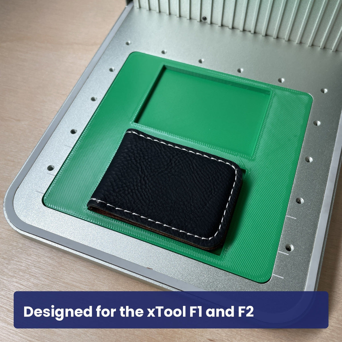 Samcraft money clip jig in the xTool F1 base plate with a black leatherette money clip seated in the recess.