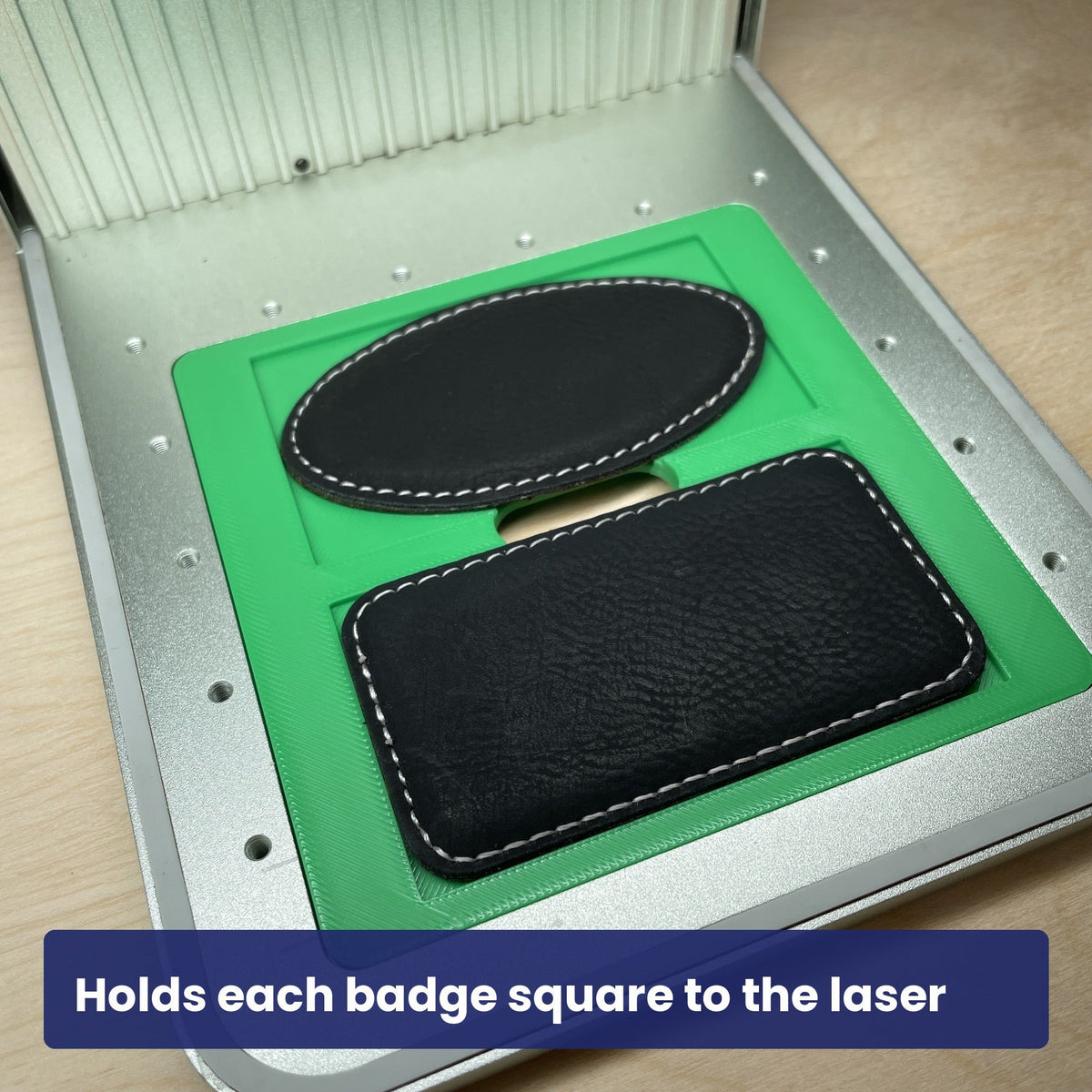 Black leatherette magnetic badges seated square in the Samcraft jig, ready to engrave.