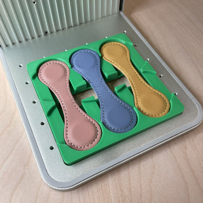 Samcraft magnetic bookmark jig in an xTool F1 laser bed, holding leather bookmarks.