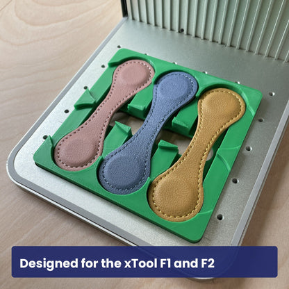 Samcraft magnetic bookmark jig seated in the xTool F1 base plate with a leather bookmark in place.