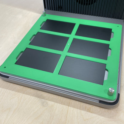 Samcraft green metal business card jig in an xTool F1 Ultra laser bed, holding six black metal business cards.