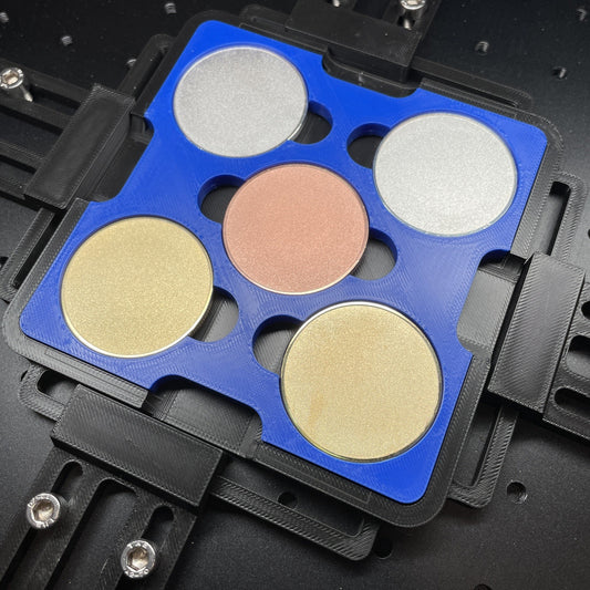 Samcraft blue 40mm metal coin jig on a ComMarker bed, holding gold, silver and copper coin blanks.