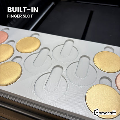 Close-up of the Samcraft 40mm coin jig showing the built-in finger slot above each empty pocket, so a coin lifts straight out without prying.