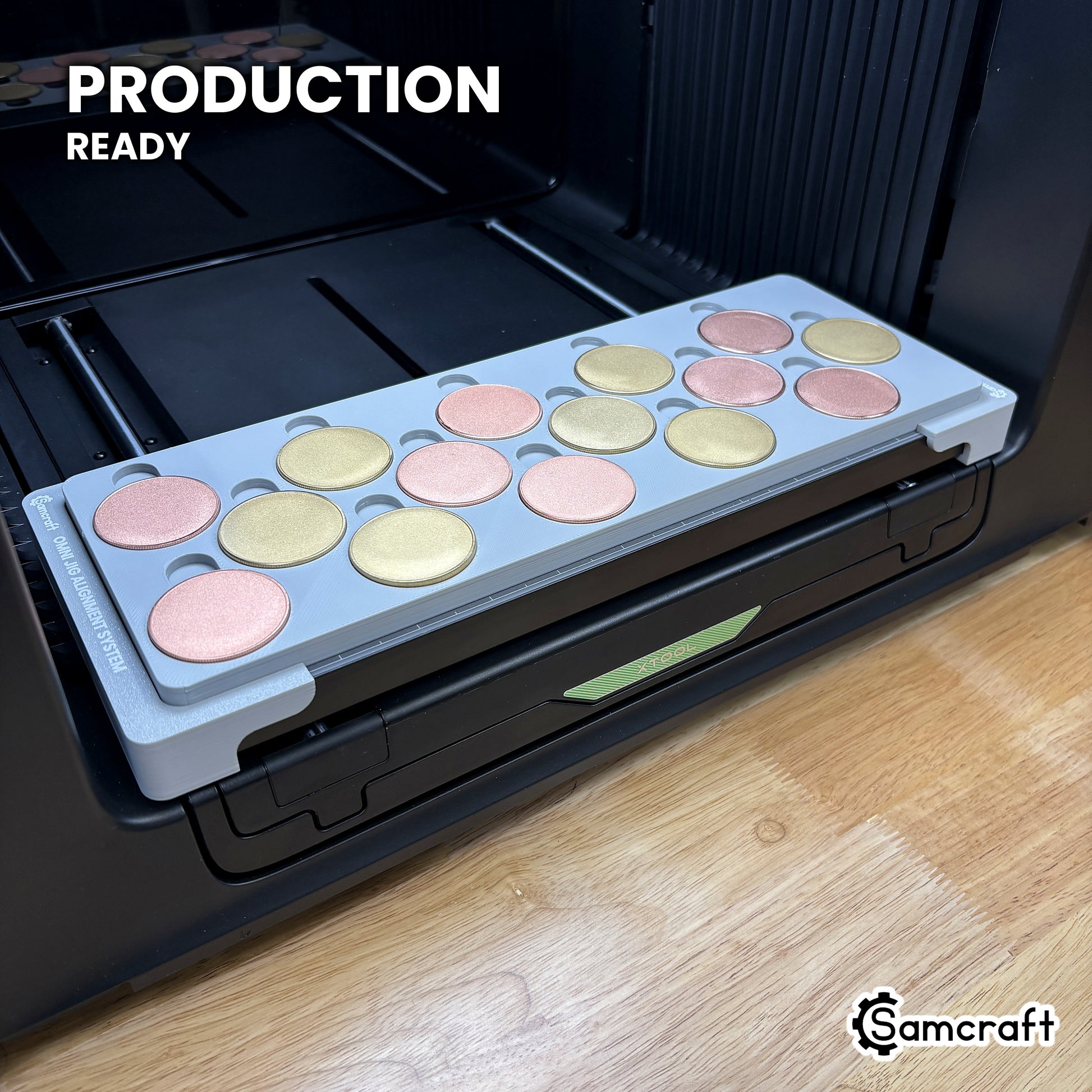 Samcraft 40mm metal coin jig holding fifteen blank challenge coins on the xTool Omni UV printer bed, set up for production runs.