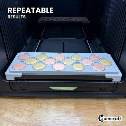 Angled view of the Samcraft 40mm metal coin jig with fifteen coins on the xTool Omni printer bed, for repeatable print placement.