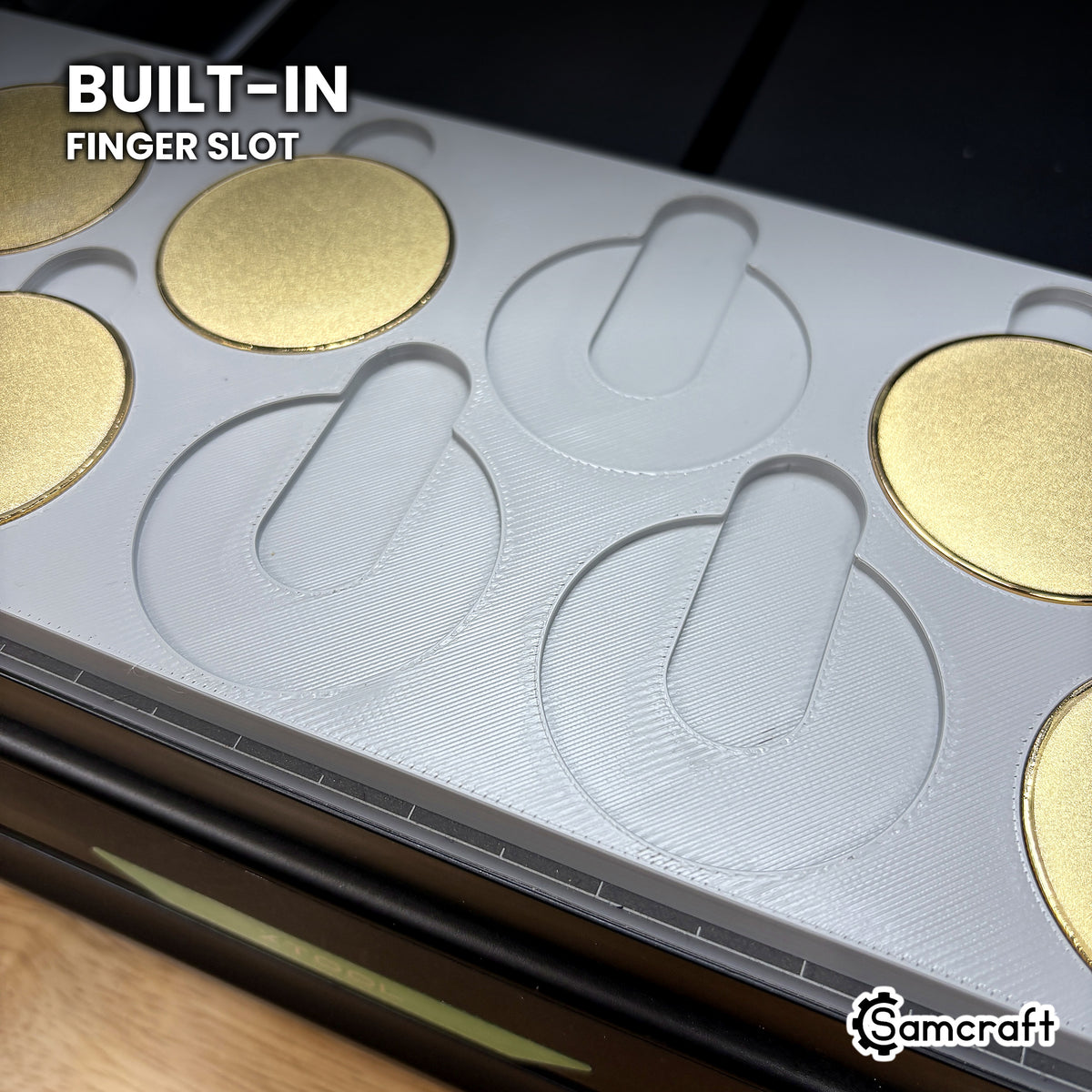 Close-up of the Samcraft 50mm coin jig showing the built-in finger slot above each empty pocket, so a coin lifts straight out without prying.