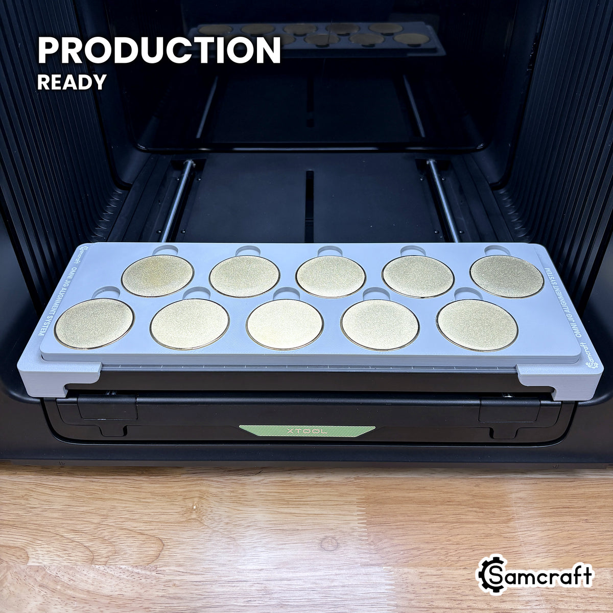 Samcraft 50mm metal coin jig holding ten blank challenge coins on the xTool Omni UV printer bed, set up for production runs.