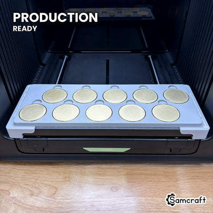 Samcraft 50mm metal coin jig holding ten blank challenge coins on the xTool Omni UV printer bed, set up for production runs.