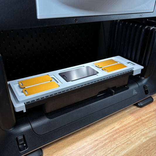 Samcraft metal luggage tag jig on the eufyMake E1 print bed, holding gold and silver metal luggage tags.