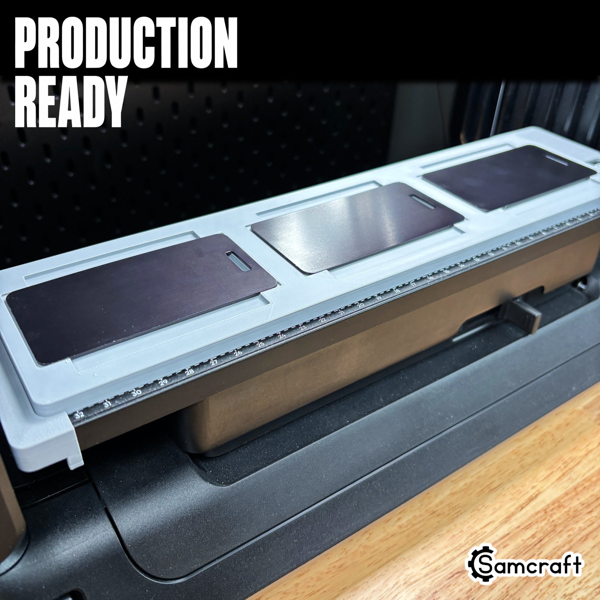 Production-ready Samcraft luggage tag jig loaded with three large black and silver metal tags, mounted on the eufyMake E1 UV printer bed.