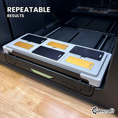 Angled view of the Samcraft metal luggage tag jig on the xTool Omni printer bed, loaded with six tags for repeatable results.