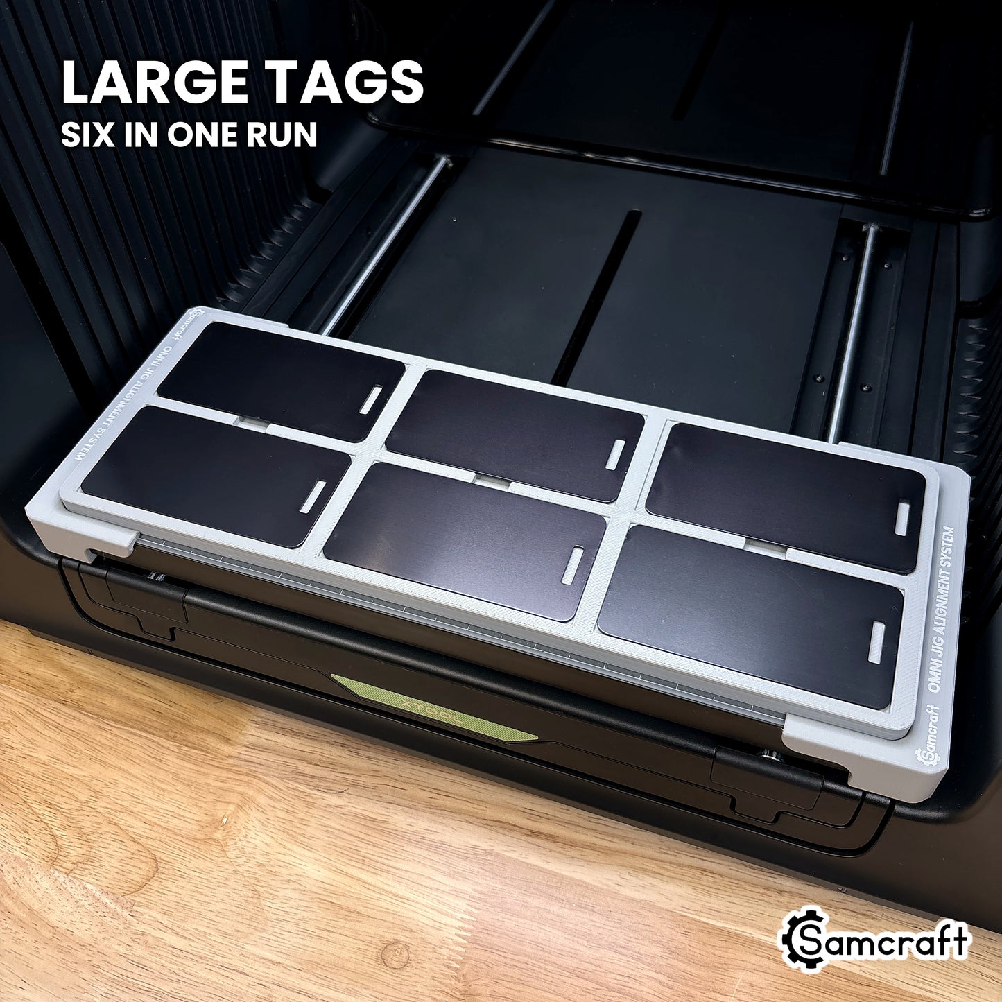 Six large black metal luggage tags filling the outer pockets of the Samcraft xTool Omni jig, six in one run.
