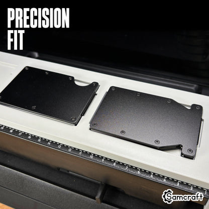 Close-up of two black metal wallets seated flush in the precision pockets of the Samcraft Metal Wallet Jig