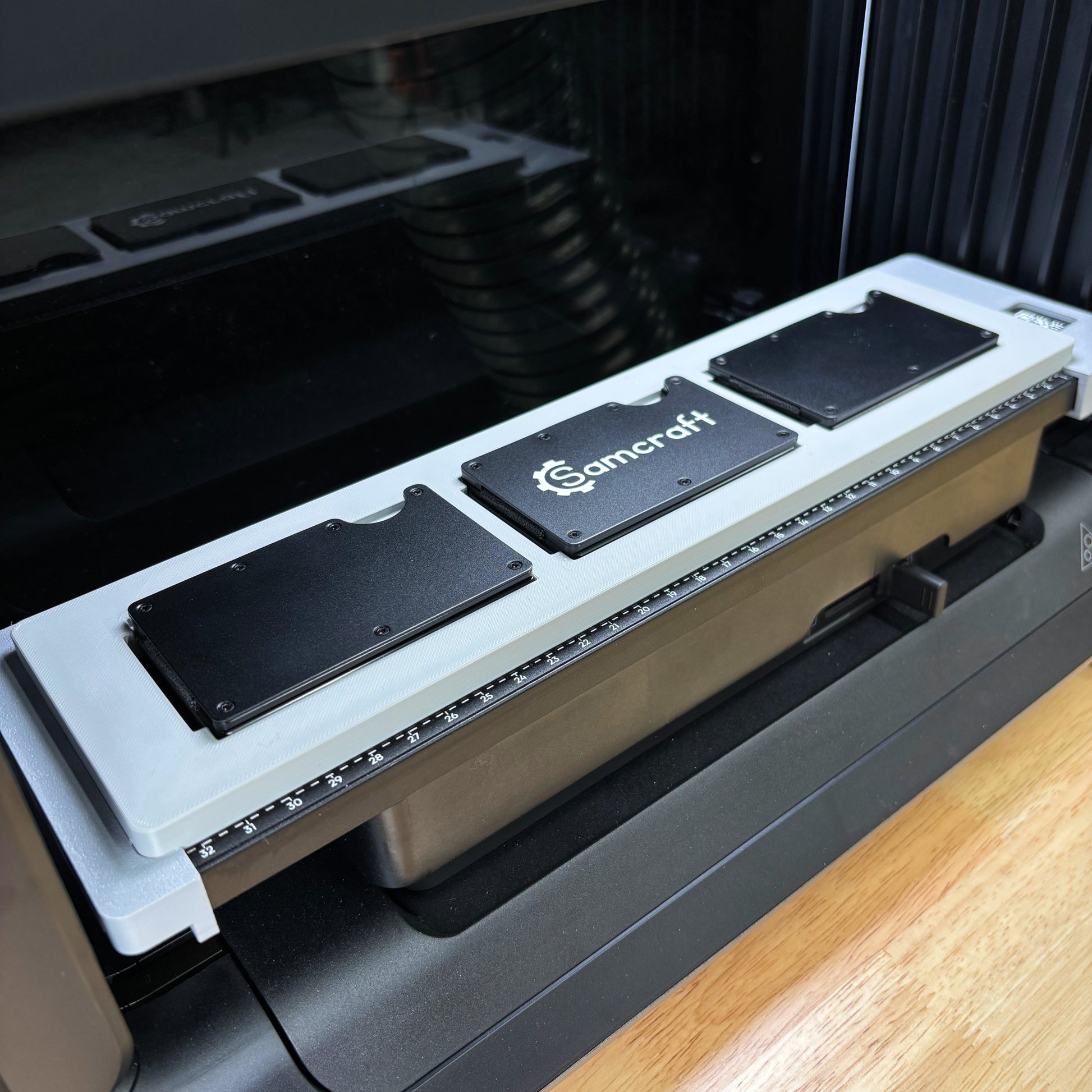 Samcraft Metal Wallet Jig holding three black metal wallets on the eufyMake E1 UV printer bed