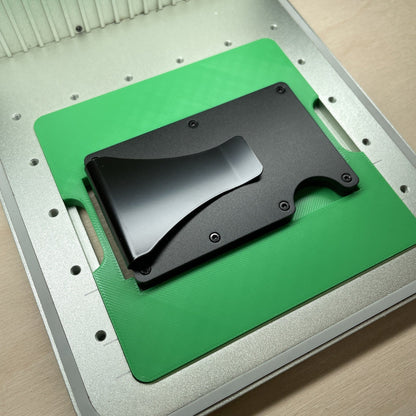 Samcraft metal wallet jig in an xTool F1 laser bed, holding a black metal card wallet.