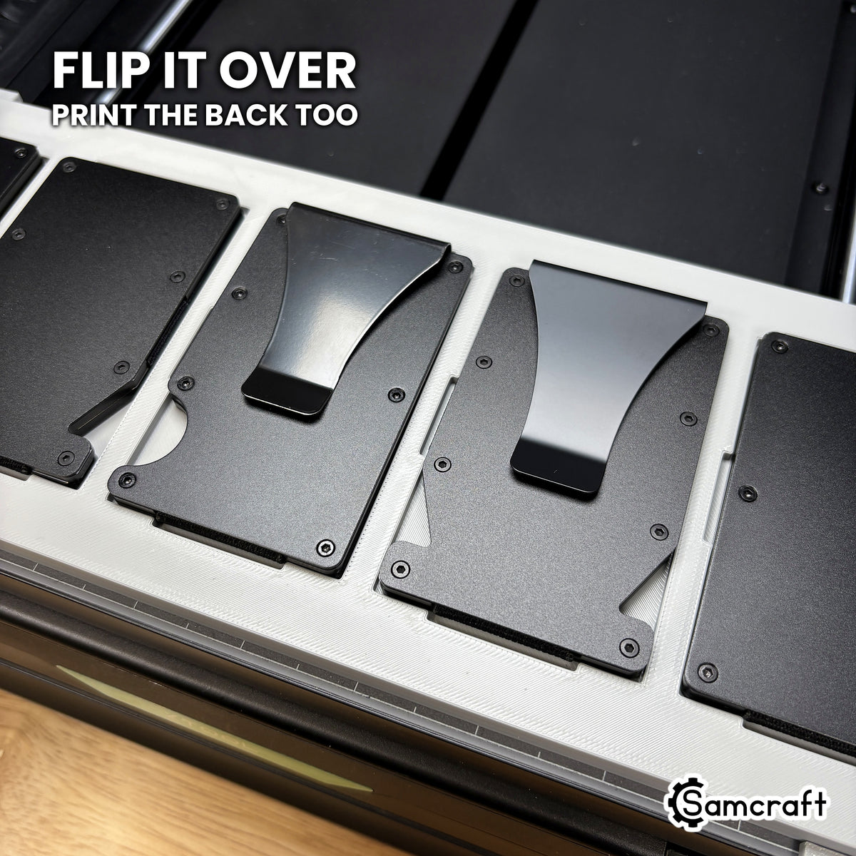 Metal wallets flipped to show the money clip side seated in the Samcraft xTool Omni jig, so the back of the wallet can be printed too.