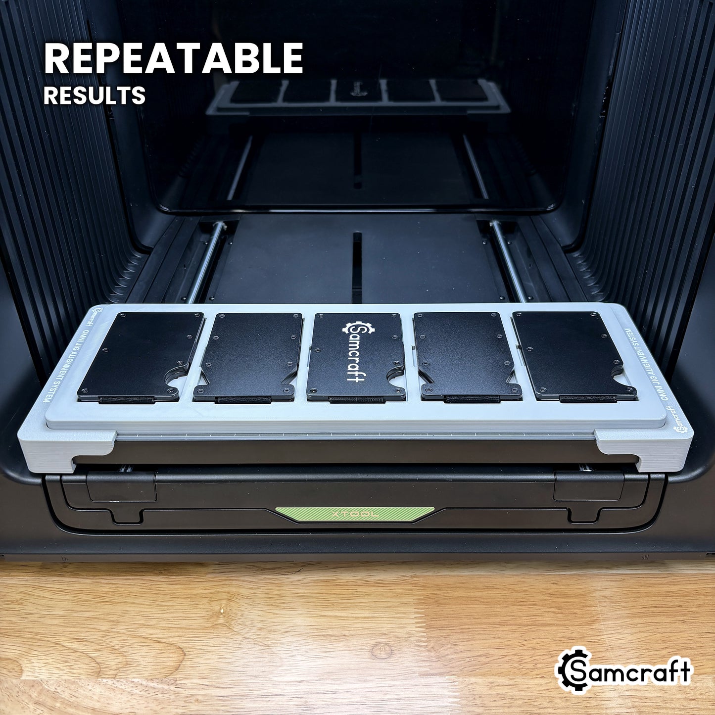 Angled view of the Samcraft metal wallet jig on the xTool Omni printer bed, loaded with five wallets for repeatable results.