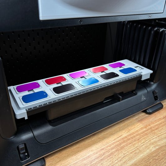 Samcraft military dog tag jig on the eufyMake E1 print bed, holding dog tags in several colours.