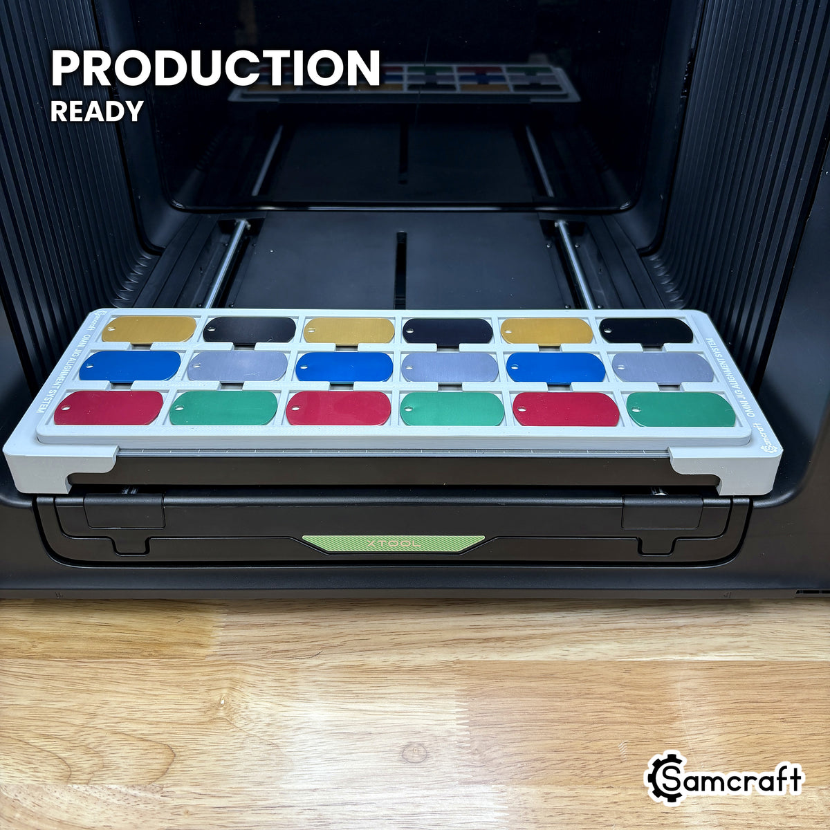Samcraft military dog tag jig loaded with eighteen tags on the xTool Omni printer bed, set up for production runs.