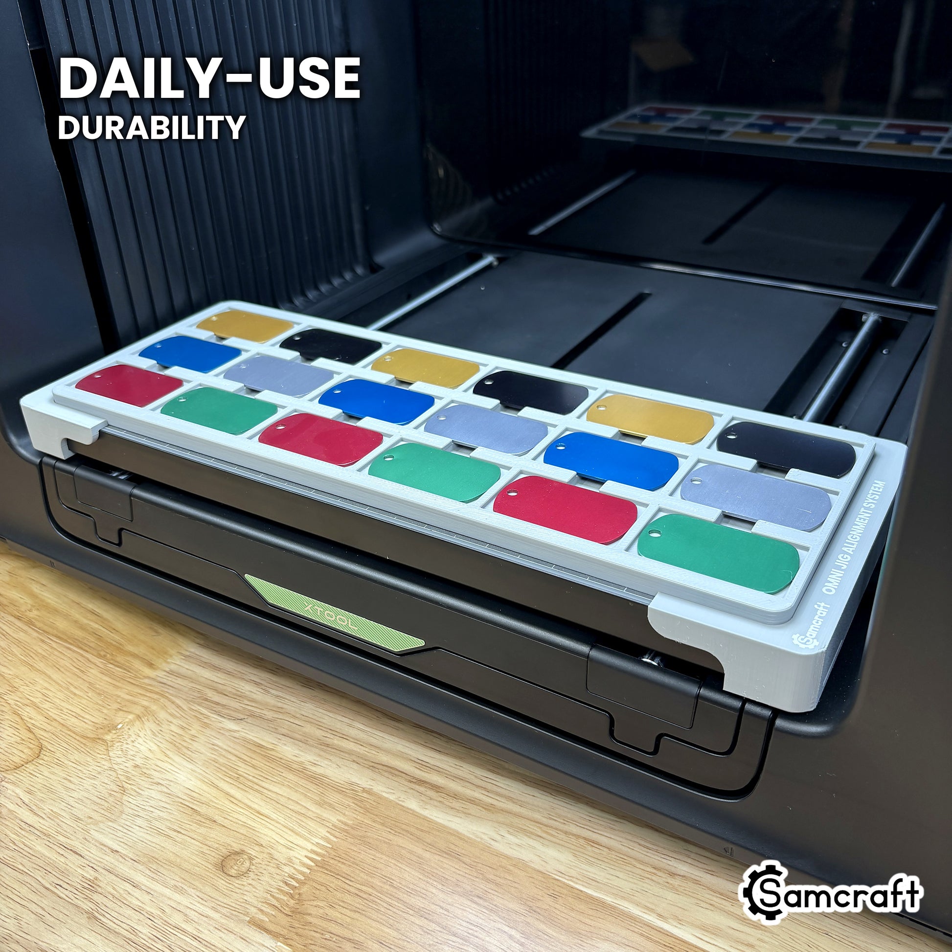 Samcraft military dog tag jig in high-temperature rated plastic holding eighteen tags on the xTool Omni bed, built for daily use.